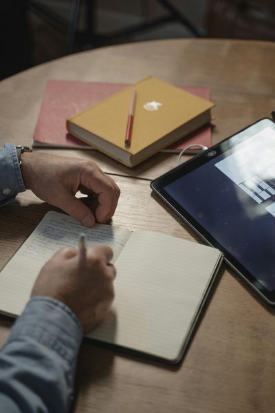 Person schreibt in Notizbuch — aktives Lesen und Notizen